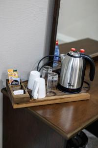 a tea kettle and cups on a table at Parallel Hotel in Baku