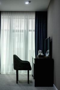 a living room with a chair and a television at Parallel Hotel in Baku