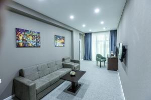 a living room with a couch and a tv at Parallel Hotel in Baku