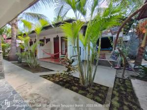 a house with palm trees in front of it at H.Said Homestay in Gili Trawangan