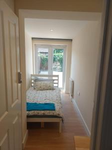 a small bedroom with a bed and a window at Vibrant Single Room only for one adult in Southall