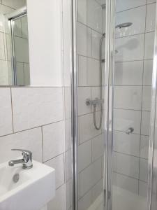 a bathroom with a shower and a sink and a mirror at Vibrant Single Room only for one adult in Southall