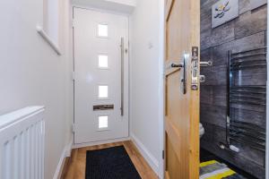 a bathroom with a white door and a black rug at Stylish 4 bedroom home close to Manchester City centre in Manchester