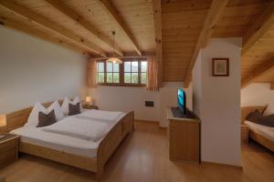 a large bedroom with a bed and a television at Moarberg in Brunico