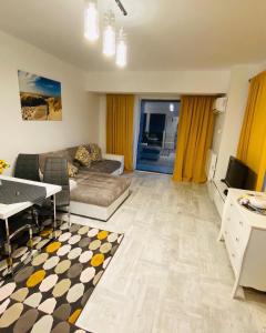 ママイアにあるSea Breeze Apartments Mamaia Nord De Silvaのリビングルーム(ソファ、テーブル付)
