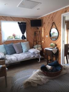 a living room with a couch and a mirror at Winganah Cottage in Murdunna