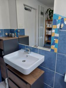 ein Badezimmer mit einem weißen Waschbecken und einem Spiegel in der Unterkunft Apartment KAYA in Mojstrana