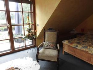 1 dormitorio con 1 cama, 1 silla y 1 ventana en Appartement im Schlösschen Nr. 2 mit Balkon, en Willich