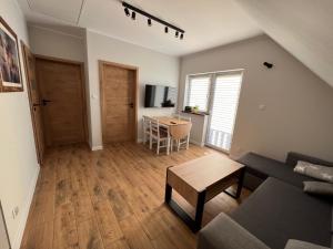 a living room with a couch and a table at Ginger Apartament in Wilkasy