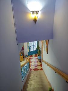 a hallway with a tile floor and a light on the ceiling at Dar Bouanani in Asilah