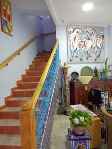 a staircase in a house with a painting on the wall at Dar Bouanani in Asilah