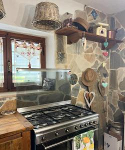 a kitchen with a stove and a stone wall at B&B Casa de' Trinci in Foligno