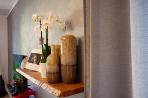 un estante con jarrones y flores en una pared en Residenza Palmina, en Rímini