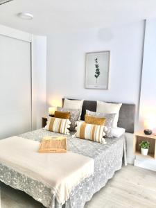 Habitación blanca con cama con almohadas en Nuevo Apto A Centrico Terraza Garaje Incluido, en Castro Urdiales