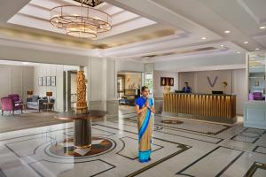 a man standing in a lobby with a statue at Vivanta Katra Vaishno Devi in Katra