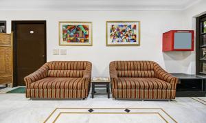 two chairs and a tv in a room at Itsy Hotels Arien International in New Delhi