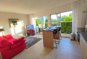a living room with a red couch and a red table at appartement entre golf, plages ,marina in Mandelieu-La Napoule