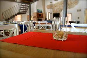 una mesa con un mantel rojo y un cristal en ella en B&B Al Tramonto Portopalo en Portopalo