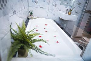 a bathroom with a bath tub with red flowers on it at GHAZRINs DESARU in Pengerang