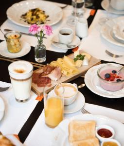 a table topped with plates of food and drinks at Hollmann Beletage Design & Boutique Hotel in Vienna