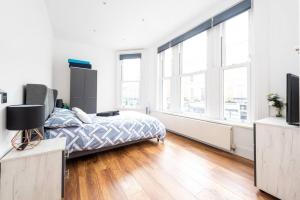 um quarto com uma cama e janelas grandes em Beautiful Apartment by Hyde Park SS2 em Londres