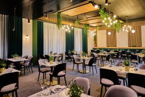 une salle à manger avec des tables, des chaises et des lustres dans l'établissement Artis Loft Hotel, à Radziejowice