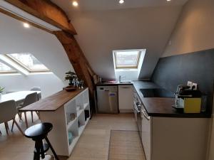 a kitchen with a counter and a table in a room at LE PANORAMA in Voiron