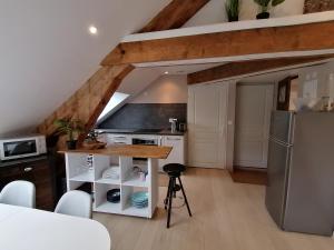 a kitchen with white cabinets and a refrigerator at LE PANORAMA in Voiron
