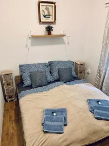 a bedroom with a bed with blue towels on it at Small Lake Apartman in Esztergom