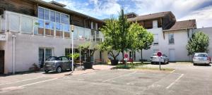 an old car parked in a parking lot in front of a building at Villa Rose de Mons - Résidence Services Senior in La Brede +1 photo