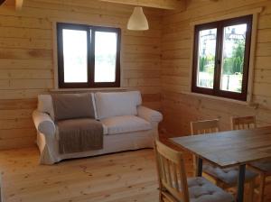 una sala de estar con un sofá y una mesa en Domek Morski 2C, en Łukęcin