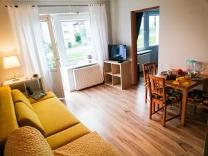 a living room with a yellow couch and a table at Malmaris in Władysławowo