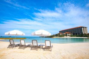 a beach with chairs and umbrellas in front of the ocean at Hyatt Regency Seragaki Island Okinawa in Onna