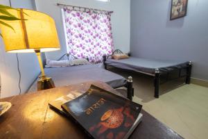 una camera con due letti e un tavolo con un libro di Samay Homestay a Dibrugarh