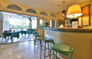 a restaurant with a bar with green chairs and tables at Hotel Biasutti in Venice-Lido