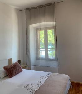 1 dormitorio con cama blanca y ventana en Bolero Guest House en Lovište