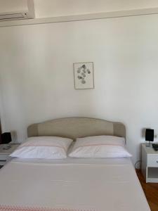 Una cama blanca con dos almohadas encima. en Bolero Guest House en Lovište