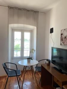 sala de estar con mesa, sillas y TV en Bolero Guest House, en Lovište