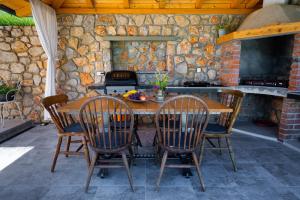 an outdoor kitchen with a wooden table and chairs at Ferienhaus Nera in Plomin