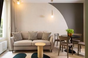 uma sala de estar com um sofá e uma mesa em Yuna Saint-Honoré - Serviced Apartments em Paris