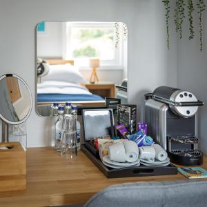 a room with a bed and a desk with a mirror at The Ship Inn in Weybourne