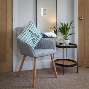 a chair with a pillow on it next to a table at The Ship Inn in Weybourne +29 photos