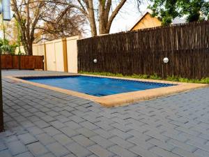 a swimming pool in a backyard with a fence at 74 on retief Guesthouse in Potchefstroom