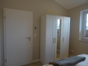 a bedroom with a white closet and a door at Ferienwohnung Judith Jensen in Wrohm