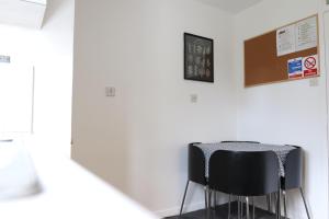 a black chair sitting next to a white wall at Bow House - SleepyLodge in London