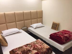 シリグリにあるAtithi Guest Houseの小さな部屋のベッド2台