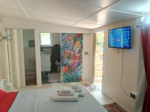 sala de estar con TV en la pared en Green Cottage en Agrigento