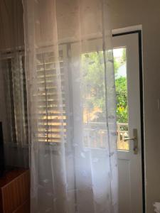a door with a window with white curtains at Bolero Guest House in Lovište +33 photos