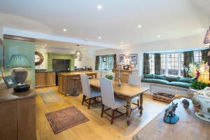 a kitchen and living room with a wooden table and chairs at The Old Post Office in Broadway