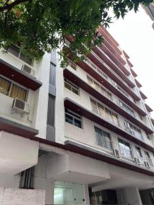 een groot appartementencomplex met balkons aan de zijkant bij Pinaki Comfort Stay, Vile Parle in Mumbai